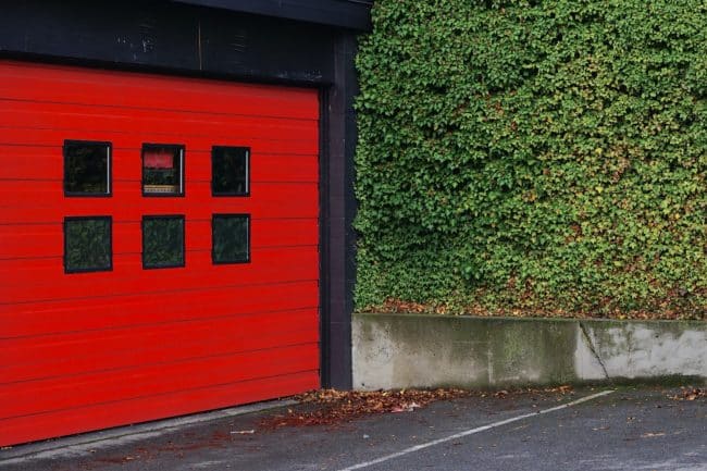 A red sectional garage door with windows